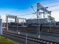 Stacja Gdynia Główna, początek lub koniec najdłuższej trasy kolejowej w Polsce. Tory, perony i budynek dworca pod błękitnym niebem.