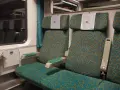 Wnętrze wagonu Intercity z zielonymi siedzeniami. Numer 46 nad zagłówkiem. Jak znaleźć wagon w pociągu Intercity?