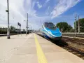 Pendolino na peronie, niebiesko-srebrny pociąg, słoneczny dzień.