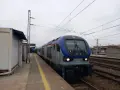 Lokomotywa PKP Intercity SU160-003 na torach kolejowych przy peronie.