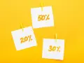 Trzy karteczki z napisami 20%, 30% i 50% przyczepione żółtymi spinaczami. Idealne zniżki dla emerytów!