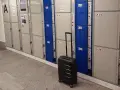 Srebrna walizka czeka przy rzędzie szafek, idealne miejsce na przechowalnia bagażu Warszawa Centralna.