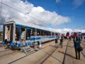 Nowy wagon PKP Intercity z niebieskim pasem, gotowy na podróż. W tle inne nowoczesne składy ec.