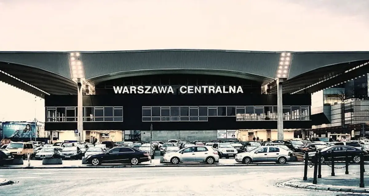 Warszawa Centralna. Po podróży pociągiem, czas na pyszne jedzenie w pobliżu dworca. Zaparkowane samochody czekają na pasażerów.