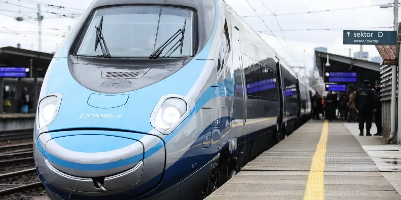 Nowoczesny, niebiesko-szary pociąg Pendolino stoi na peronie.