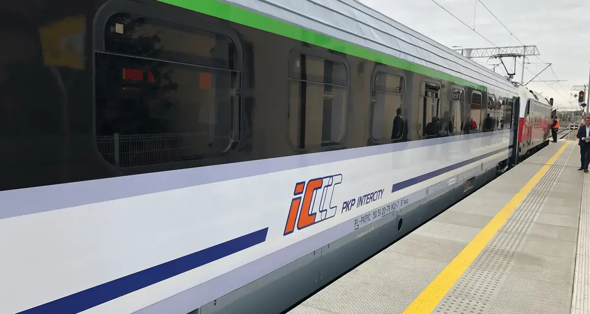 Pociąg PKP Intercity z charakterystycznym logo eic i eip stoi na peronie.