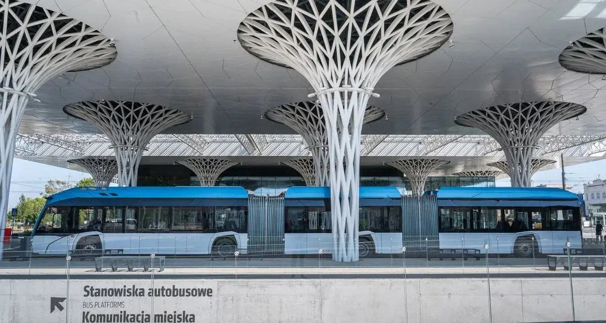 Nowoczesny dworzec autobusowy w Lublinie, z niebieskim autobusem i charakterystycznymi, drzewiastymi podporami dachu. Podróż z Lublina do Białej Podlaskiej tym środkiem transportu to czysta przyjemność.