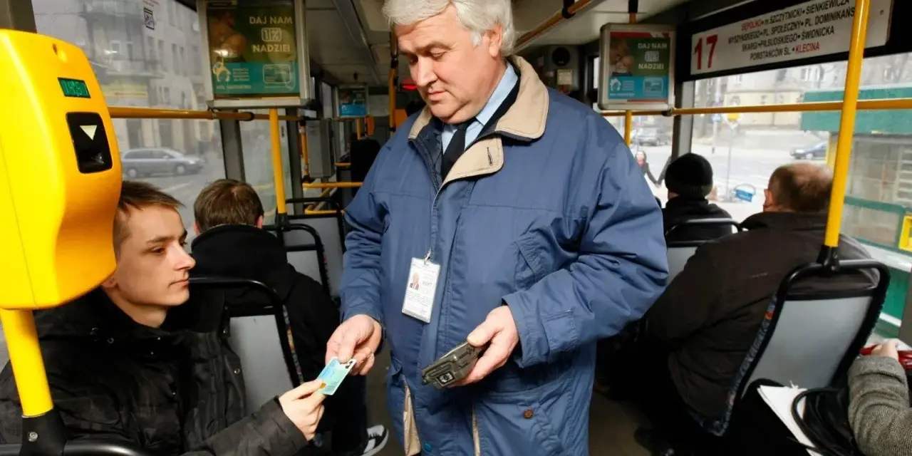 Kontroler biletów w niebieskiej kurtce sprawdza bilet młodego pasażera w autobusie.