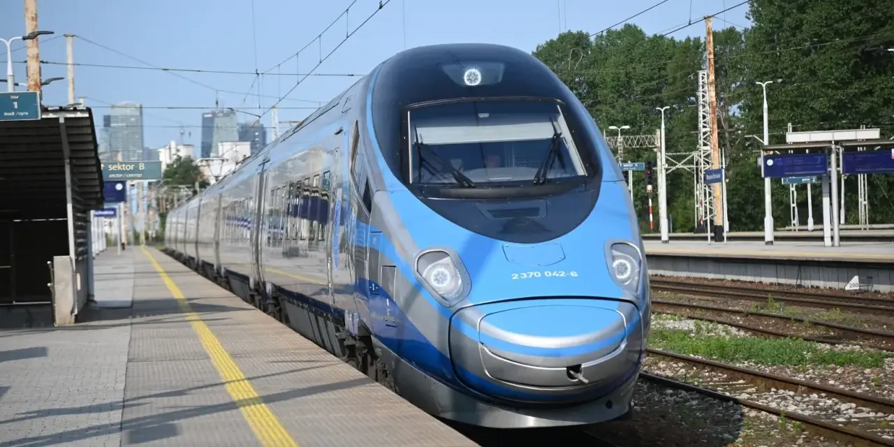 Niebiesko-srebrny pociąg Pendolino na peronie dworca kolejowego.