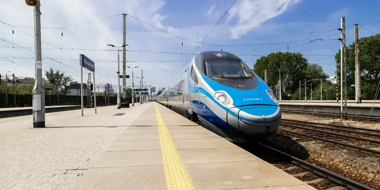 Pendolino na peronie, niebiesko-srebrny pociąg, słoneczny dzień.