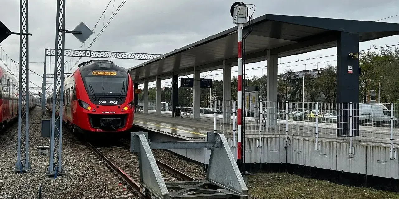 Czerwony pociąg SKM na peronie dworca kolejowego.
