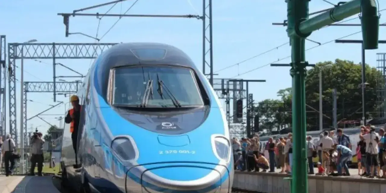 Błękitno-szary pociąg Pendolino na peronie, ludzie czekają na podróż. Oznaczenie Pendolino w rozkładzie jazdy.