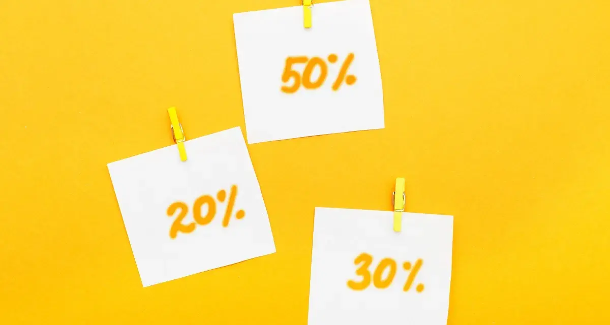 Trzy karteczki z napisami 20%, 30% i 50% przyczepione żółtymi spinaczami. Idealne zniżki dla emerytów!