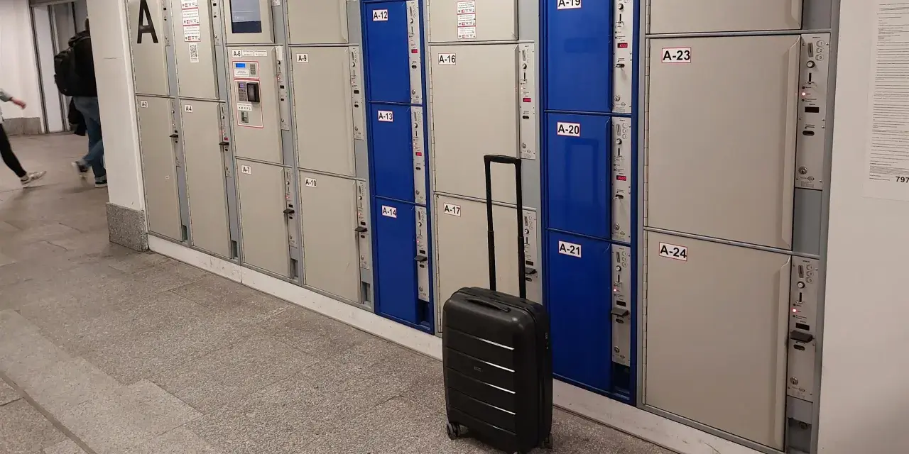 Srebrna walizka czeka przy rzędzie szafek, idealne miejsce na przechowalnia bagażu Warszawa Centralna.