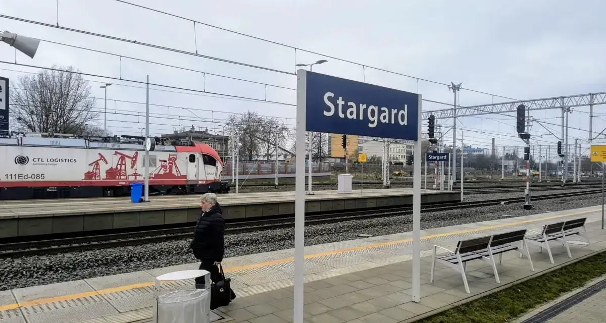 Kobieta czeka na peronie w Stargardzie. W tle pociąg towarowy CTL Logistics.