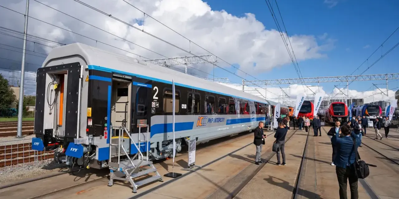 Nowy wagon PKP Intercity z niebieskim pasem, gotowy na podróż. W tle inne nowoczesne składy ec.
