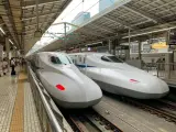 Dwa białe pociągi Shinkansen stojące na peronie, gotowe do podróży.