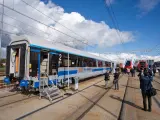 Nowy wagon PKP Intercity z niebieskim pasem, gotowy na podróż. W tle inne nowoczesne składy ec.