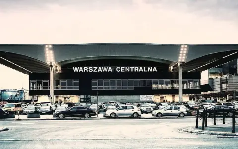 Warszawa Centralna. Po podróży pociągiem, czas na pyszne jedzenie w pobliżu dworca. Zaparkowane samochody czekają na pasażerów.