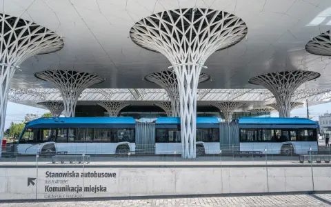 Nowoczesny dworzec autobusowy w Lublinie, z niebieskim autobusem i charakterystycznymi, drzewiastymi podporami dachu. Podróż z Lublina do Białej Podlaskiej tym środkiem transportu to czysta przyjemność.