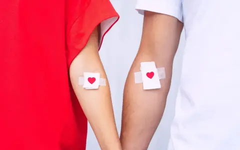 Dwie ręce z plastrami w kształcie serca. To symbol wsparcia dla krwiodawców i przypomnienie o zniżkach dla krwiodawców.
