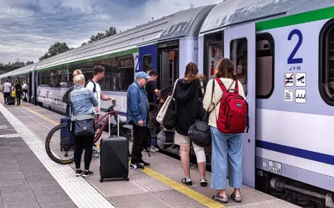 Ludzie z bagażami i rowerami czekają na pociąg PKP. Może właśnie skorzystają ze zniżki PKP na podróż?
