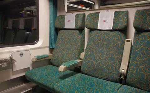 Wnętrze wagonu Intercity z zielonymi siedzeniami. Numer 46 nad zagłówkiem. Jak znaleźć wagon w pociągu Intercity?