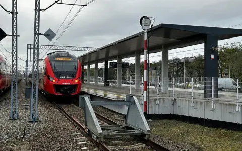 Czerwony pociąg SKM na peronie dworca kolejowego.