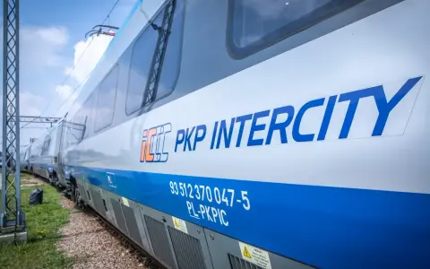 Pociąg PKP Intercity z niebieskim pasem i logo.