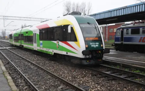 Pociąg z napisem "Zielona Góra" na torach, z zielonymi i białymi pasami na karoserii.