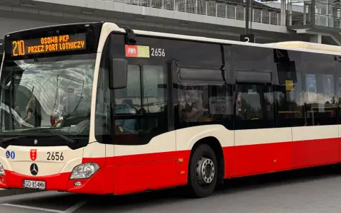 Autobus linii 210 "Osoba PKP przez Port Lotniczy" czeka na pasażerów. To wygodny dojazd z dworca PKP do lotniska w Gdańsku.