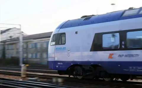 Pociąg PKP Intercity Stadler ED160-007 mija budynek. Może to być widok podczas przebukowania biletu na podróż.