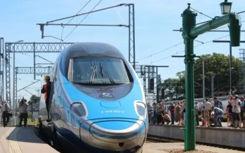 Błękitno-szary pociąg Pendolino na peronie, ludzie czekają na podróż. Oznaczenie Pendolino w rozkładzie jazdy.