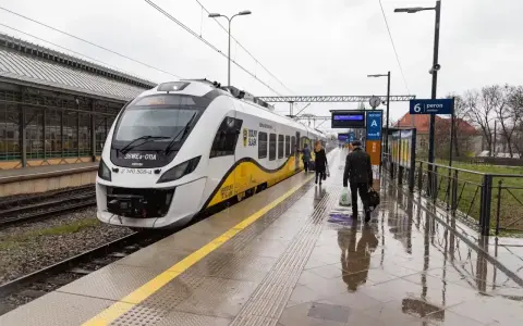 Nowoczesna hulajnoga elektryczna czeka na podróż w pociągu na mokrym peronie.