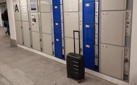 Srebrna walizka czeka przy rzędzie szafek, idealne miejsce na przechowalnia bagażu Warszawa Centralna.