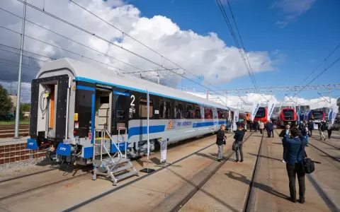 Nowy wagon PKP Intercity z niebieskim pasem, gotowy na podróż. W tle inne nowoczesne składy ec.