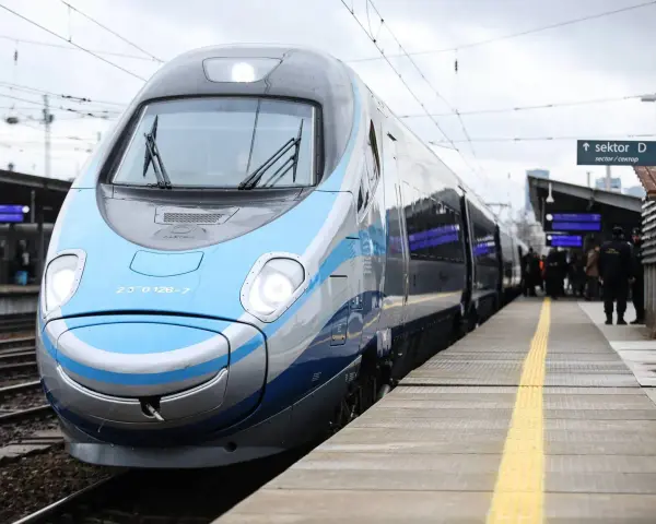 Nowoczesny, niebiesko-szary pociąg Pendolino stoi na peronie.