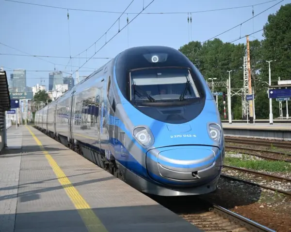 Niebiesko-srebrny pociąg Pendolino na peronie dworca kolejowego.