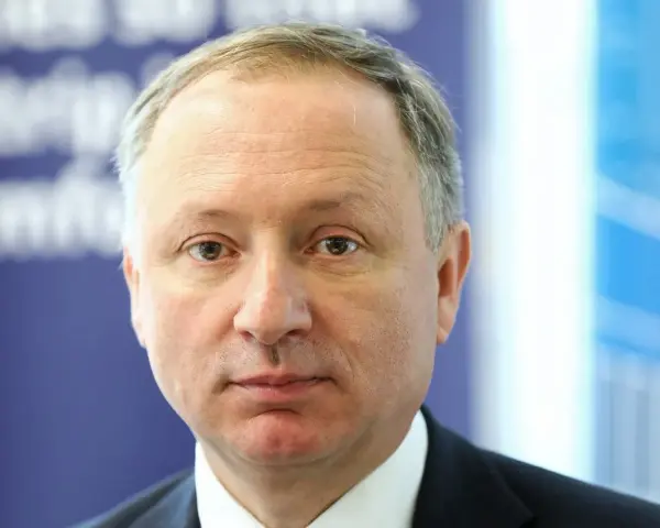 Prezes PKP, mężczyzna w garniturze, patrzy prosto w obiektyw.