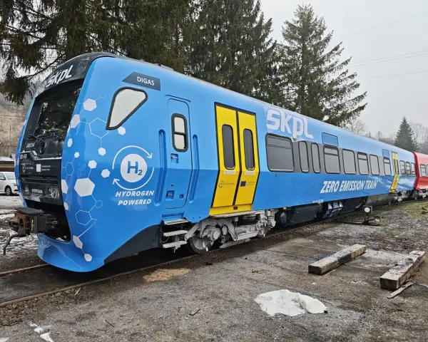 Niebieski pociąg SKPL z napędem wodorowym, oznaczony jako "ZERO EMISSION TRAIN", stoi na torach.