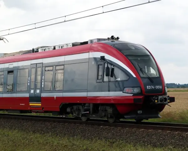 Nowoczesny pociąg PKP, idealny do sprawdzenia pkp busko-zdrój rozkład jazdy. Pędzi przez pola.