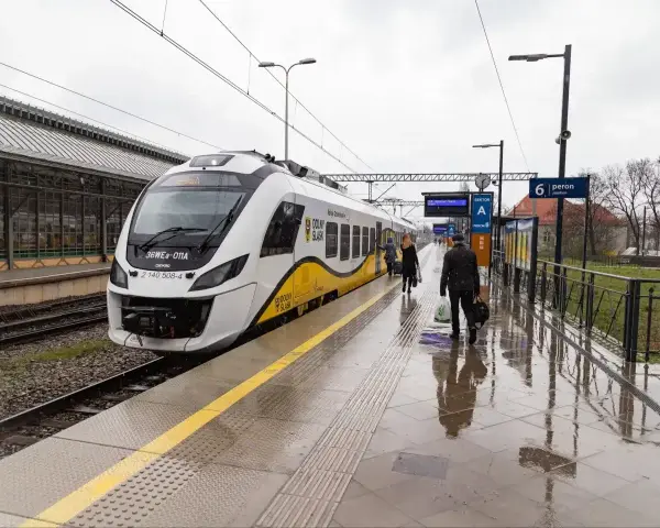 Nowoczesna hulajnoga elektryczna czeka na podróż w pociągu na mokrym peronie.
