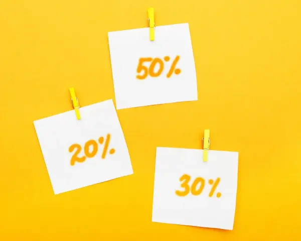 Trzy karteczki z napisami 20%, 30% i 50% przyczepione żółtymi spinaczami. Idealne zniżki dla emerytów!