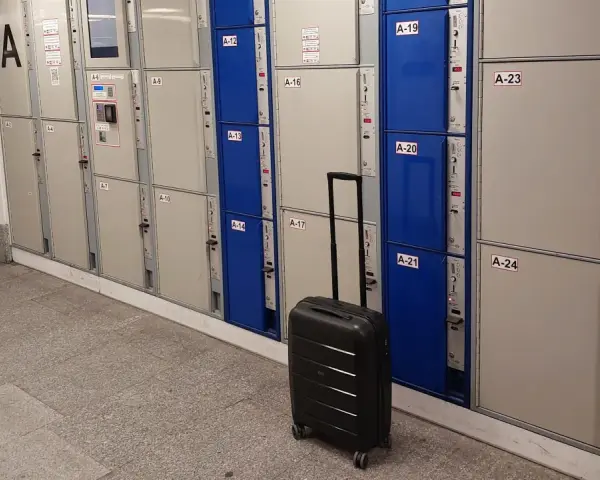 Srebrna walizka czeka przy rzędzie szafek, idealne miejsce na przechowalnia bagażu Warszawa Centralna.