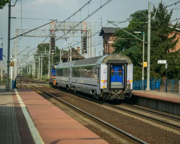Pociąg Polregio z wygodnymi miejscami siedzącymi stoi na peronie.
