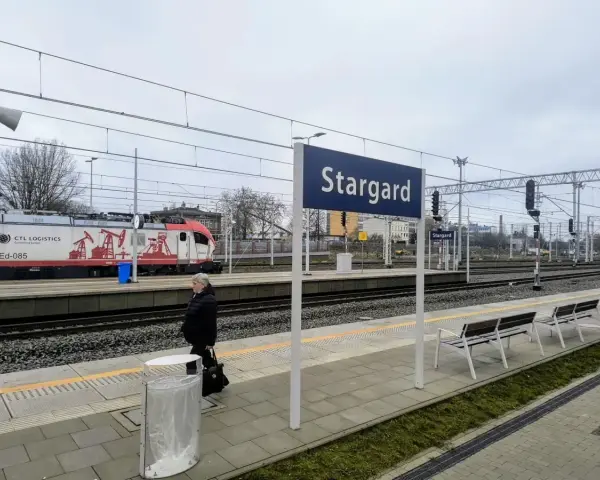 Kobieta czeka na peronie w Stargardzie. W tle pociąg towarowy CTL Logistics.