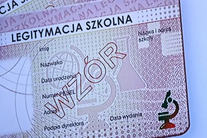 Fragment legitymacji szkolnej z napisem "WZÓR" i mikroskopem.