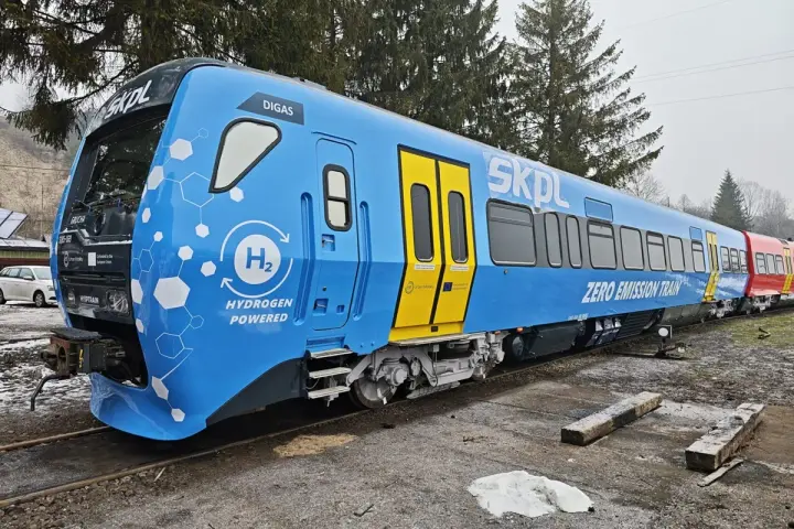 Niebieski pociąg SKPL z napędem wodorowym, oznaczony jako "ZERO EMISSION TRAIN", stoi na torach.