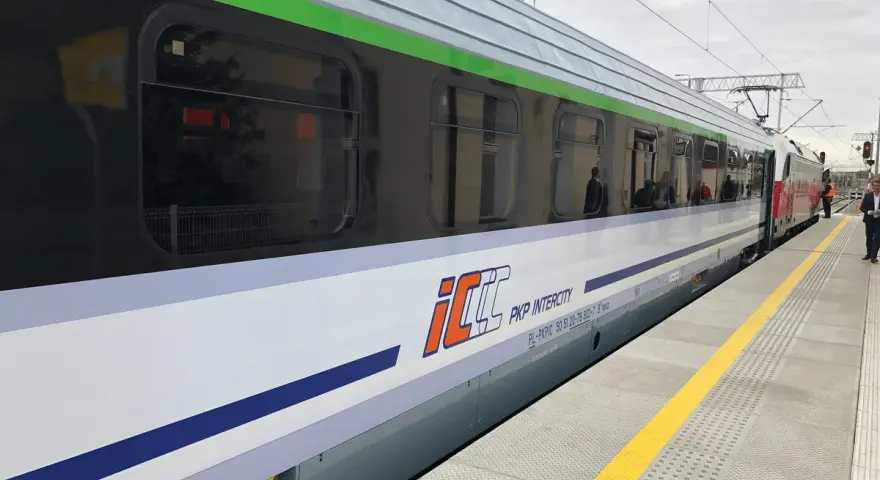 Pociąg PKP Intercity z charakterystycznym logo eic i eip stoi na peronie.