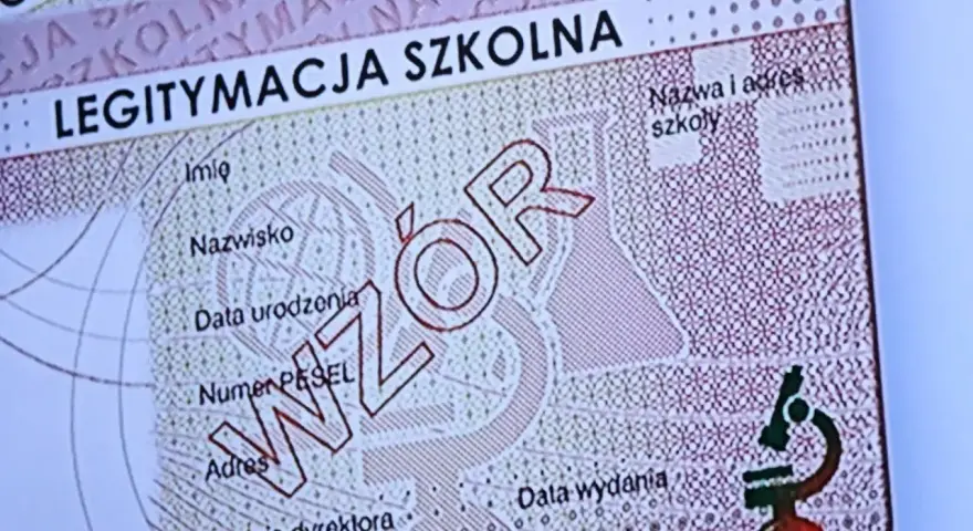 Fragment legitymacji szkolnej z napisem "WZÓR" i mikroskopem.
